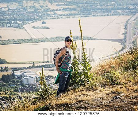 Young Woman Posing With Great Yellow Gentian Plant Over The Nitra City