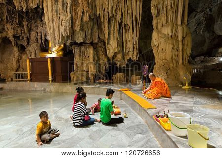 KANCHANABURI, THAILAND, JANUARY 19, 2016 : A thai family is praying and meditating with a Buddhist monk in the Wat Tham Pu Wa cave temple in Kanchanaburi, Thailand