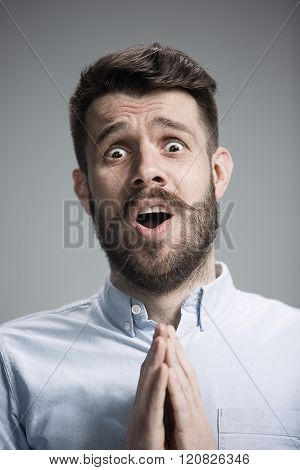 Man is looking imploring over gray background