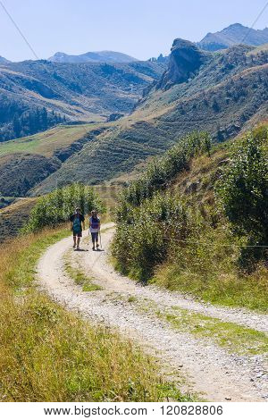 Couple Of Hikers In Prato Nevoso In The Ligurian Alps Piedmont During The Summer Season.