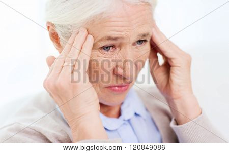 health care, pain, stress, age and people concept - face of senior woman suffering from headache