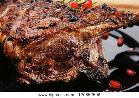 roasted ribs on black plate on wooden table