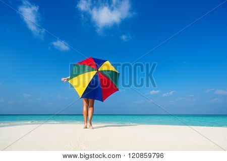 Girl With An Colorful  Umbrella On The Sandy Beach
