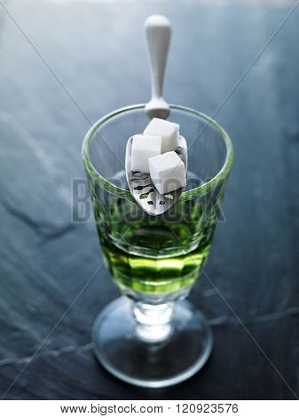 absinthe in pontarlier glass with spoon and sugar cubes