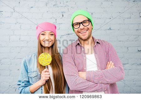 Portrait Of Bright Hipster Cheerful Couple In Love With Lollipop