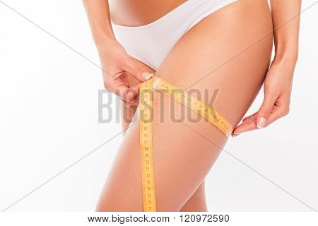 Close Up Photo Of Girll Measuring Her Leg's Size With Tape Measure