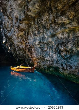 small boat inside a cave lake with blue water in kefallonia greece