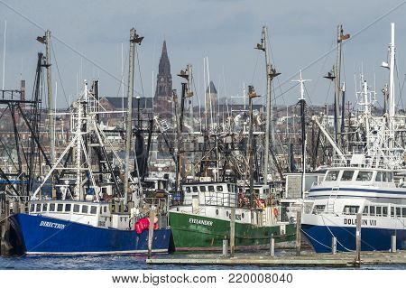 Fairhaven, Massachusetts, USA - December 26, 2017: Fishing boats and ferry docked in Fairhaven with New Bedford in background