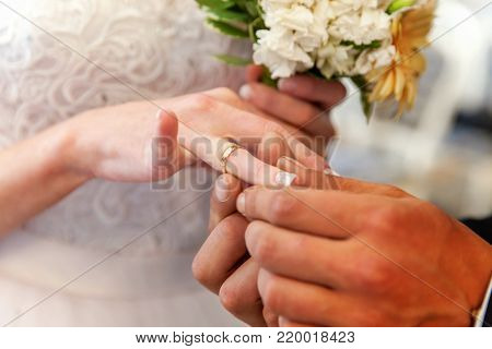 marriage hands with rings. groom's hand putting a wedding ring on the bride's finger