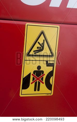 Warning sign on agricultural machinery. Do not stand behind the tractor. It is possible to get a shock. Observe the distance.