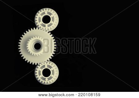 Three plastic gears on a black background.