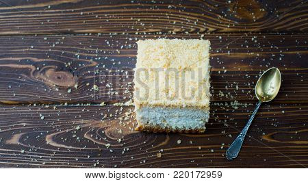 Delicious Piece Of Cake With A Spoon On A Wooden Table. Crumbs On A Wooden Table With A Cake.