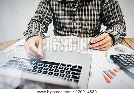 Men are calculating individual income tax to send information to government agencies. Using a laptop and a calculator.