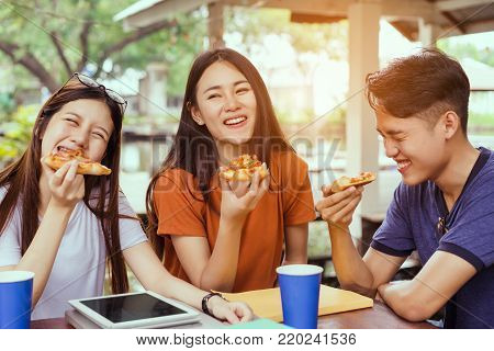 Asian group together eating pizza in breaking time having fun and enjoy party italian food slice with cheese delicious