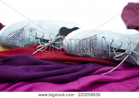 Stylish female sneakers shoes and colourful tippet scarf isolated on white background.