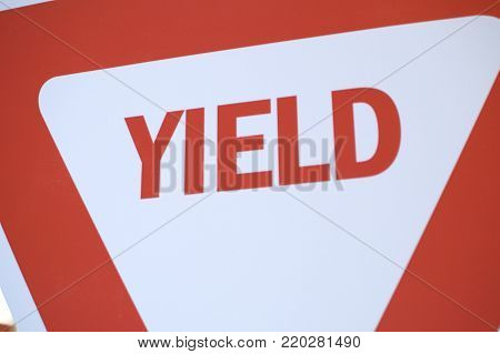 Red and white inverted triangle yield sign