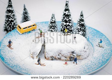 macro of miniature skiers on a plate with cake