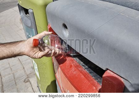 Trash Segregation, Man putting empty plastic bottle in recycling bin, Yazd, Iran.