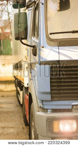 The truck on the road is blue, standing in the parking lot is resting. stop