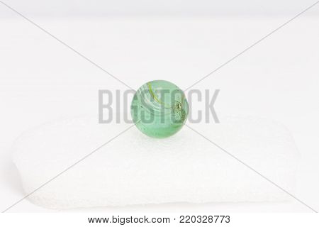 a green marble with white and yellow stripes