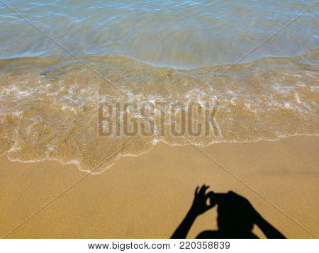Silouhette of Person, Taking Cell Phone Photo of Sandy Beach, on a Sunny Day