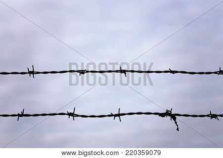 Barbed Wire Fence with Moody Sky Background