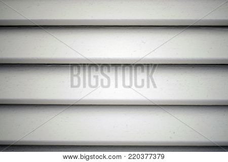 White wooden blinds create horizontal shadows and pattern.