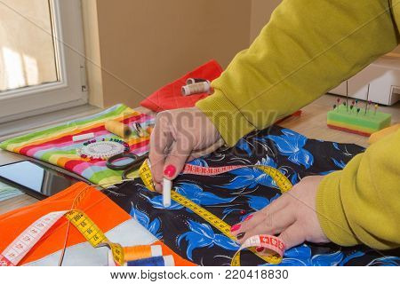 Tailor Woman working in his tailor shop, Tailoring. Tailor working at the studio. woman's hand sew cloth. Handmade. hands of female by needlework