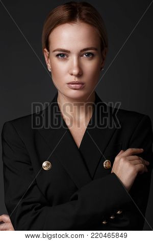 sexy fashion model with long hair, young European attractive, beautiful eyes, perfect skin is posing in studio for glamour vogue test photo shoot showing different poses. Picture taken in the studio on a gray background.