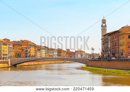 Ponte di Mezzo (Mezzo Bridge) on Arno river with Pisa cityscape in the background in Tuscany, Italy