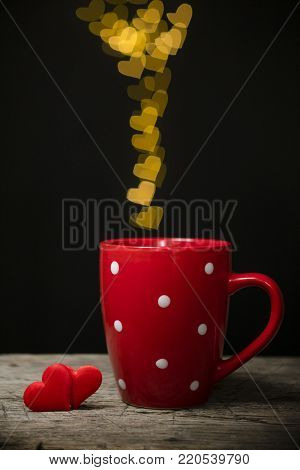 Valentine's day concept with hearts and cup over black background