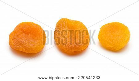 Three whole dried apricots in row isolated on white background