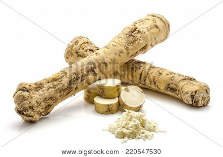 Two whole, one half, sliced circles and freshly grated mash of horseradish root, isolated on white background