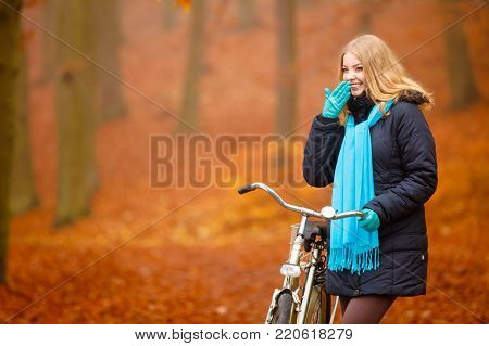 Fall active lifestyle concept. Beauty young woman girl waering vivid color shawl relaxing in autumnal park with bicycle outdoor