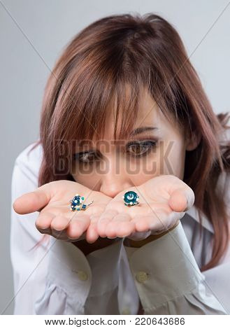 Woman looking at earrings on gray background