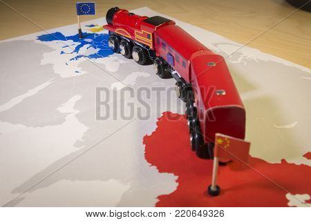 Toy train connecting Europa and China. Symbolizing the New Silk Road or one belt one road Chinese strategic investment in the 21st century. Economic project to connect EU, Central Asia and China