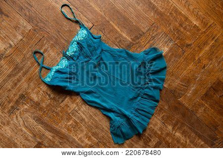 top view of woman blue dress nightie thrown on the wooden floor