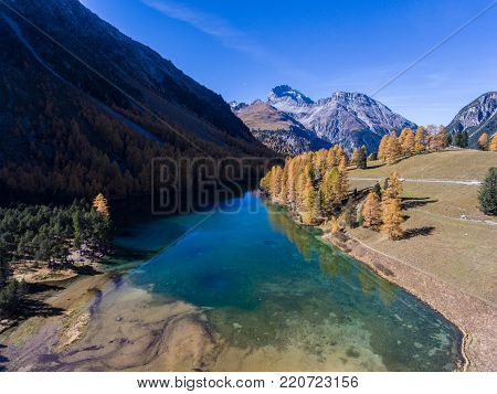 Mountain lake in the Swiss Alps lined with autumnal trees