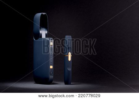 Newest electronic cigarettes, heating tobacco system IQOS, smoking, device isolated on black background