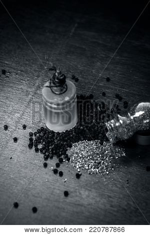 Close Up Of Oil Of Black Pepper,piper Nigrum With Raw Black Pepper And Powder On A Wooden Surface.
