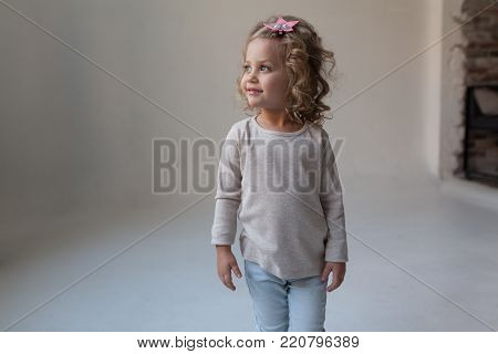 A nice little girl in a gray blank sweatshirt. Mock up.