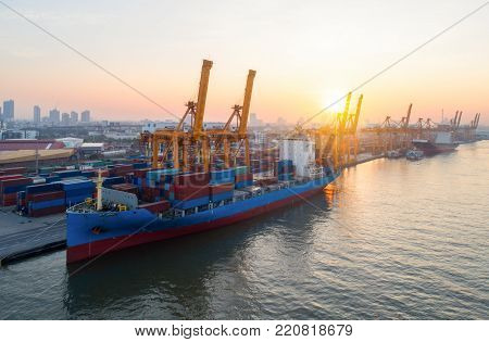 Aerial view of Containers yard shot from drone in port congestion with ship vessels are loading and discharging operations of the transhipments in international port.Shot from drone