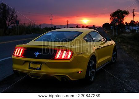 Oaxaca, Mexico - May 26, 2017: Yellow muscle car Ford Mustang at the interurban road.