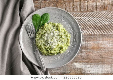 Plate with tasty spinach risotto on table, top view