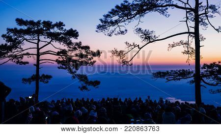 People watching Sunrise in the morning. Tourists travel relax in the holiday. photograph sunrise in the morning among people. Thailand