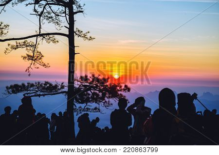 People watching Sunrise in the morning. Tourists travel relax in the holiday. photograph sunrise in the morning among people. Thailand