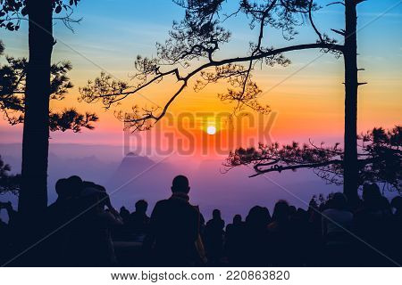People watching Sunrise in the morning. Tourists travel relax in the holiday. photograph sunrise in the morning among people. Thailand