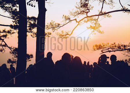 People watching Sunrise in the morning. Tourists travel relax in the holiday. photograph sunrise in the morning among people. Thailand