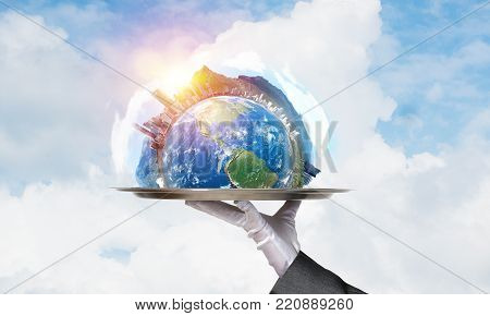 Cropped image of waitress's hand in white glove presenting Earth globe on metal tray with cloudy skyscape on background. 3D rendering. Elements of this image are furnished by NASA.