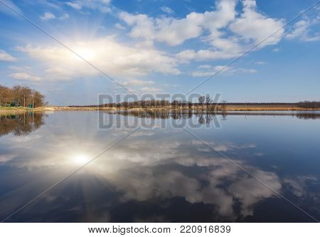 Natural landscape, tree without leaves, river, shore, forest, river grass, reflection many trees blue sky ravines
